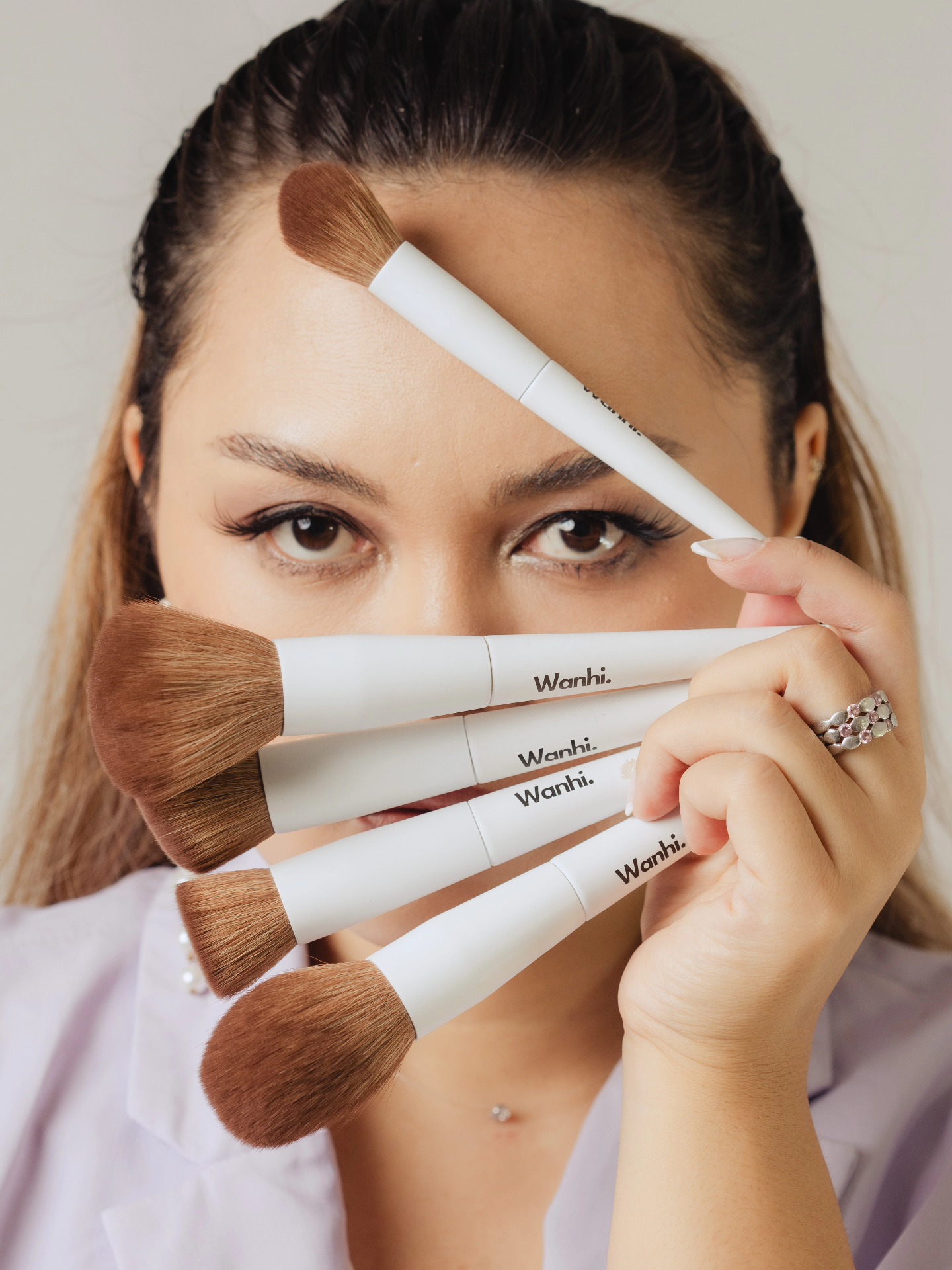 Femme tenant des pinceaux de maquillage Wahni